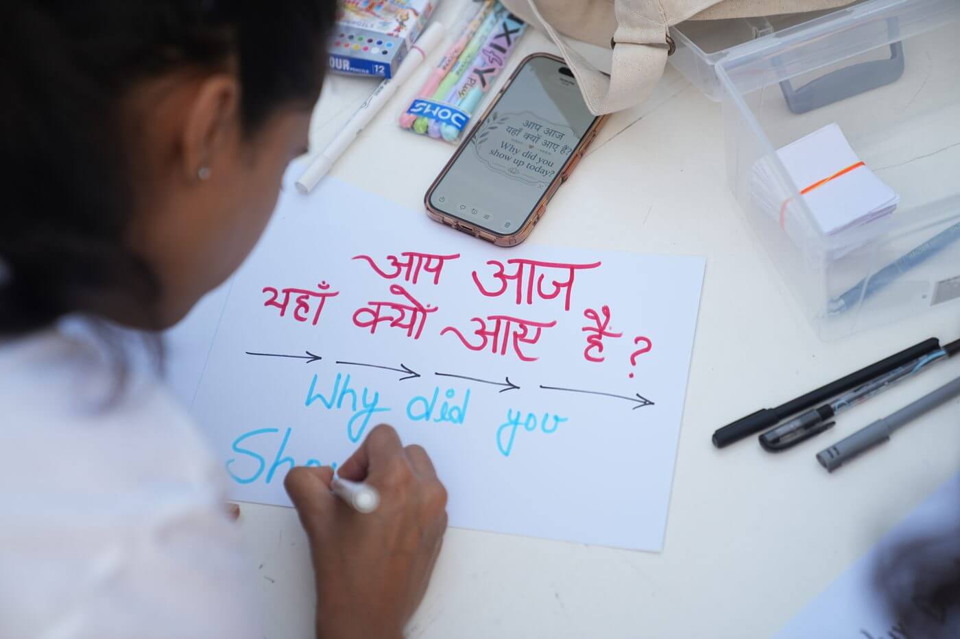 Girl writing bilingual sign at IYD 2026 registration