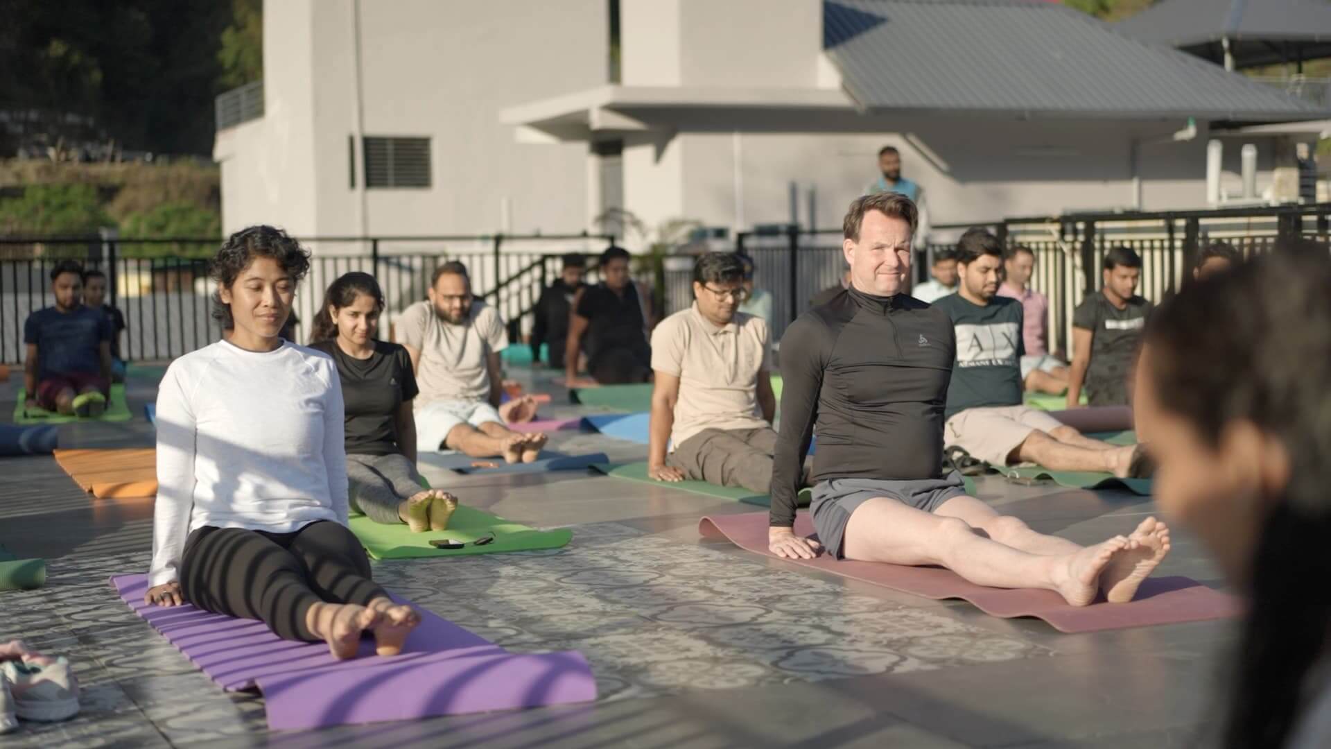 Diverse international IT team on colourful yoga mats at Rishikesh resort — morning session